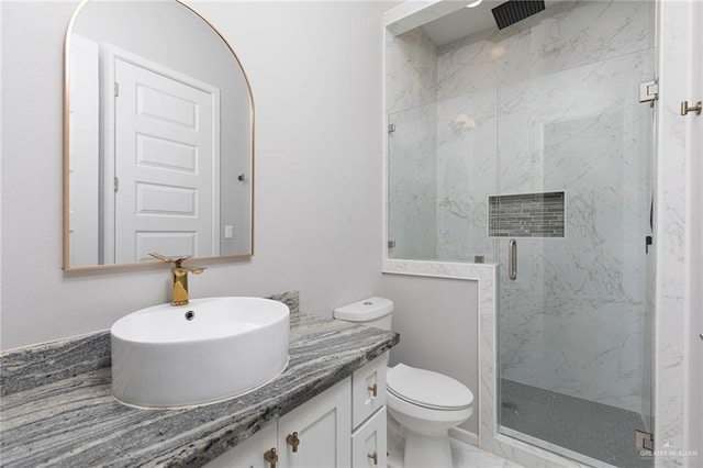 bathroom featuring a marble finish shower, toilet, marble finish floor, and vanity