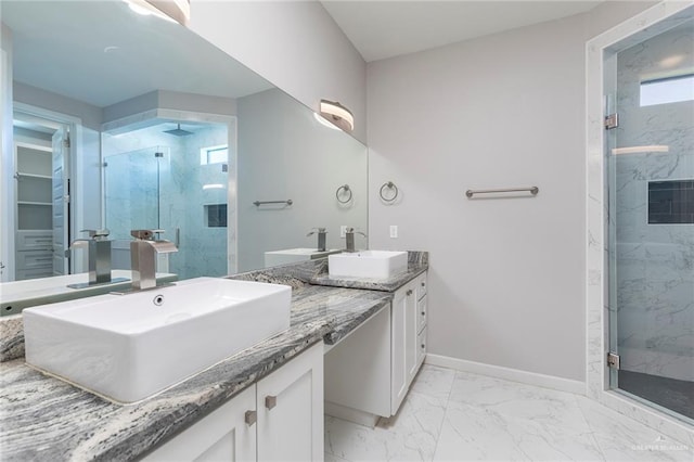 full bathroom featuring a marble finish shower, marble finish floor, baseboards, and a sink