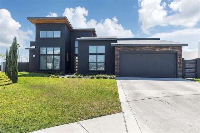 view of front facade featuring a front yard, stucco siding, a garage, stone siding, and driveway