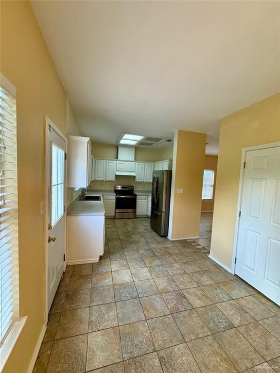 2100 Emory Ave, Mcallen, TX 78504 - kitchen featuring baseboards, stainless steel electric range oven, a wealth of natural light, and freestanding refrigerator