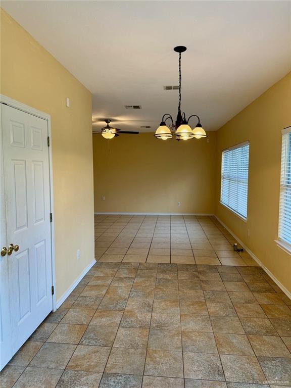 2100 Emory Ave, Mcallen, TX 78504 - spare room with visible vents, ceiling fan with notable chandelier, and baseboards