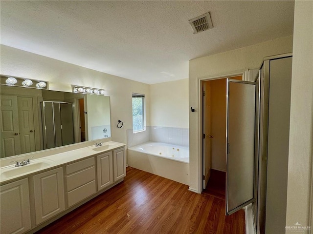 2100 Emory Ave, Mcallen, TX 78504 - full bathroom with a textured ceiling, a sink, wood finished floors, and visible vents