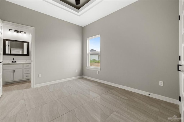 unfurnished bedroom featuring ensuite bathroom and sink