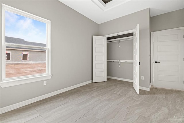 unfurnished bedroom with a closet and lofted ceiling