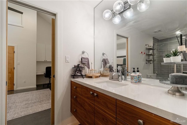 2411 Holland Ave, Edinburg, TX 78539 - full bath featuring tiled shower, vanity, and wood finished floors