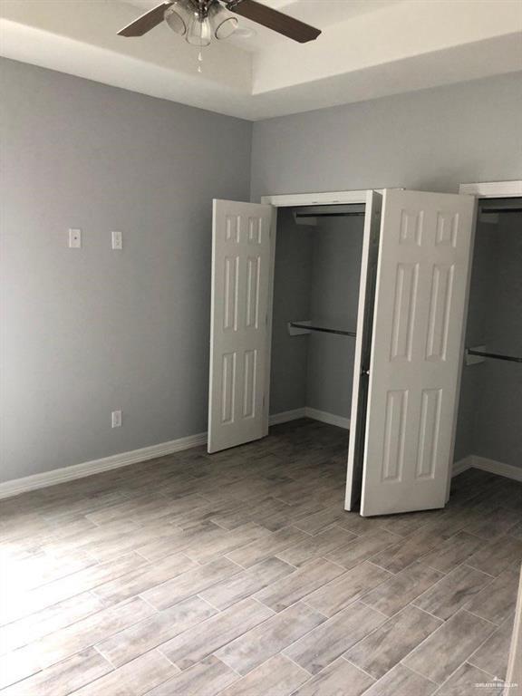 2705 Primrose Ave, Edinburg, TX 78541 - unfurnished bedroom with a closet, ceiling fan, and a tray ceiling