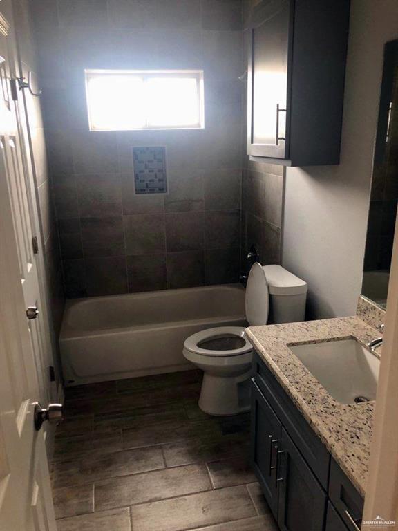 2705 Primrose Ave, Edinburg, TX 78541 - full bathroom featuring vanity, tiled shower / bath combo, and toilet