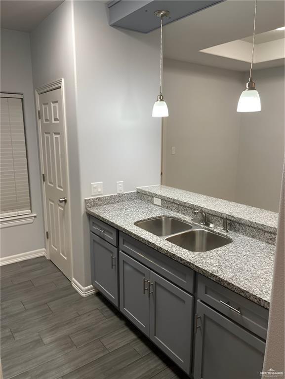 2705 Primrose Ave, Edinburg, TX 78541 - kitchen with gray cabinetry, decorative light fixtures, light stone countertops, and sink