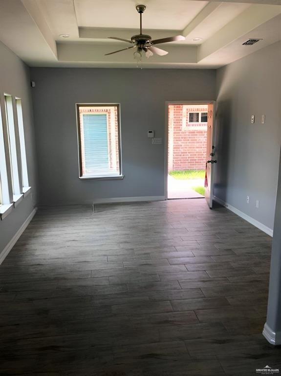 2705 Primrose Ave, Edinburg, TX 78541 - empty room with a tray ceiling, ceiling fan, and dark hardwood / wood-style floors