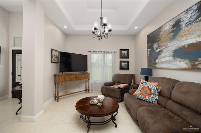 living room with light tile patterned floors, a raised ceiling, and a notable chandelier