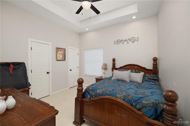 tiled bedroom featuring a raised ceiling and ceiling fan