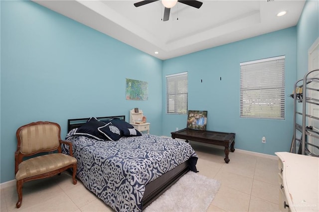 bedroom with a raised ceiling, ceiling fan, and light tile patterned floors