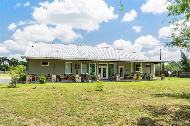 back of property featuring a yard and french doors