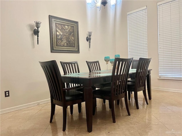 dining area with light tile patterned floors and a chandelier