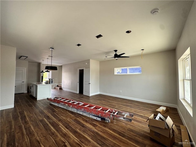 living room with dark wood finished floors, plenty of natural light, and a ceiling fan