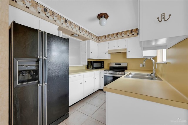 5618 Jack Nicklaus Dr, Palm Valley, TX 78552 - kitchen with light tile patterned floors, under cabinet range hood, a sink, light countertops, and black appliances