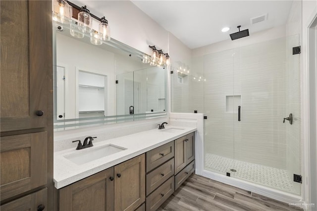 bathroom featuring hardwood / wood-style floors, vanity, and an enclosed shower