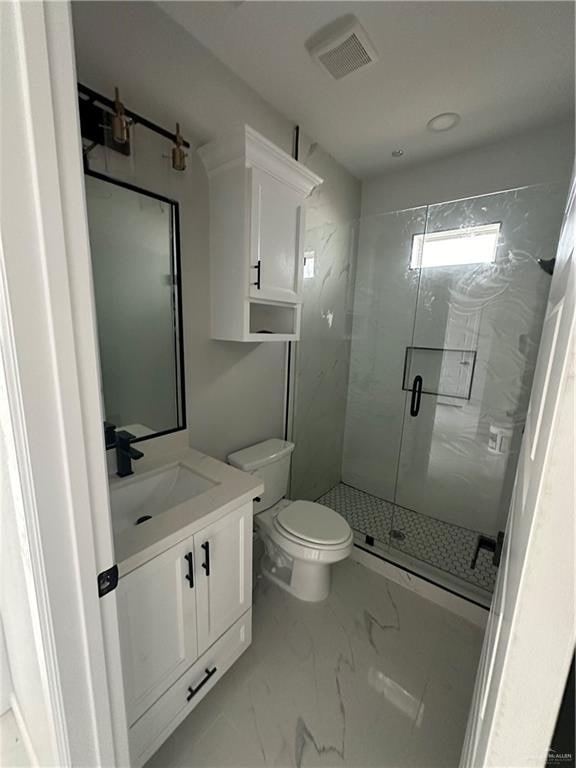 bathroom with a shower with door, vanity, and toilet