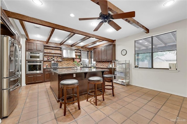 1205 Susan Dr, Edinburg, TX 78539 - kitchen featuring open shelves, a healthy amount of sunlight, beamed ceiling, a kitchen bar, and appliances with stainless steel finishes