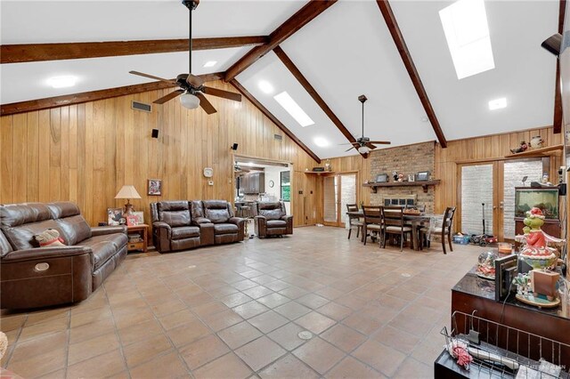 1205 Susan Dr, Edinburg, TX 78539 - living area with ceiling fan, visible vents, vaulted ceiling with skylight, and wooden walls