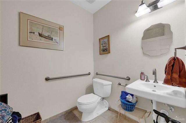 1205 Susan Dr, Edinburg, TX 78539 - half bathroom featuring baseboards, tile patterned flooring, a sink, and toilet