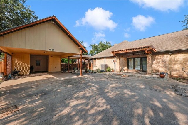 1205 Susan Dr, Edinburg, TX 78539 - rear view of house featuring brick siding, fence, a carport, and a pergola