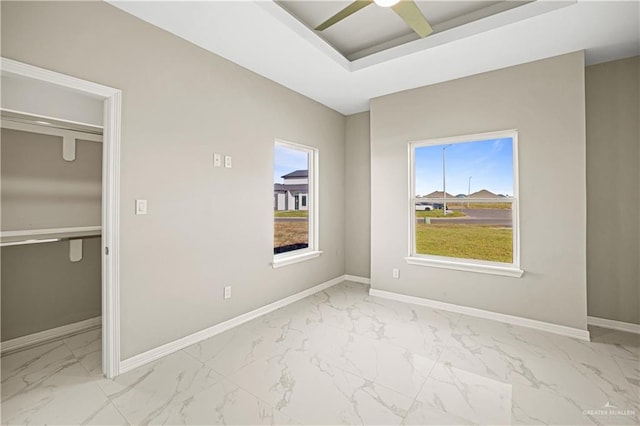 unfurnished bedroom featuring multiple windows, ceiling fan, and a closet