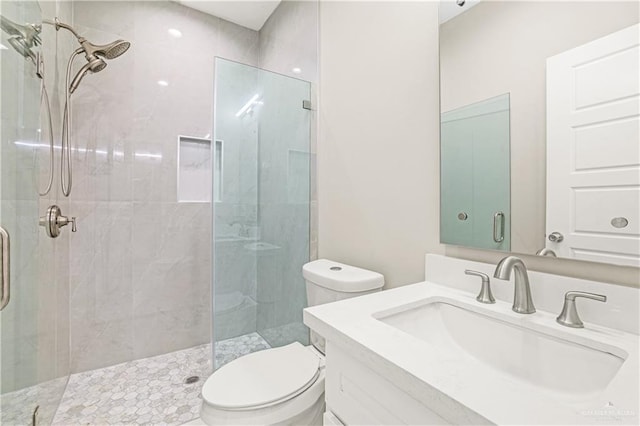 bathroom with vanity, toilet, and a shower with shower door