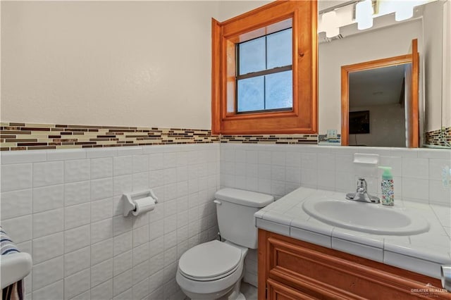 bathroom with vanity, tile walls, and toilet