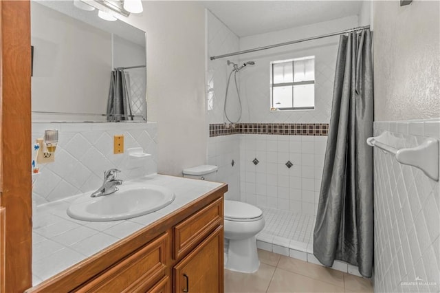 bathroom with tile patterned floors, vanity, tile walls, toilet, and curtained shower