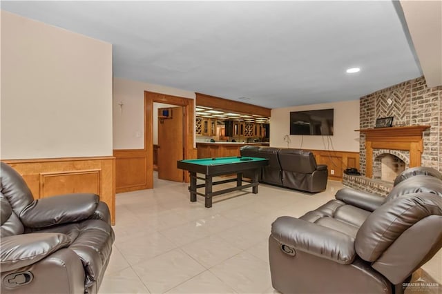 game room featuring a brick fireplace, wooden walls, and billiards