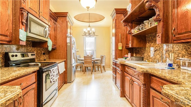 2904 Victoria St, Hidalgo, TX 78557 - kitchen with appliances with stainless steel finishes, a chandelier, backsplash, and light tile patterned floors