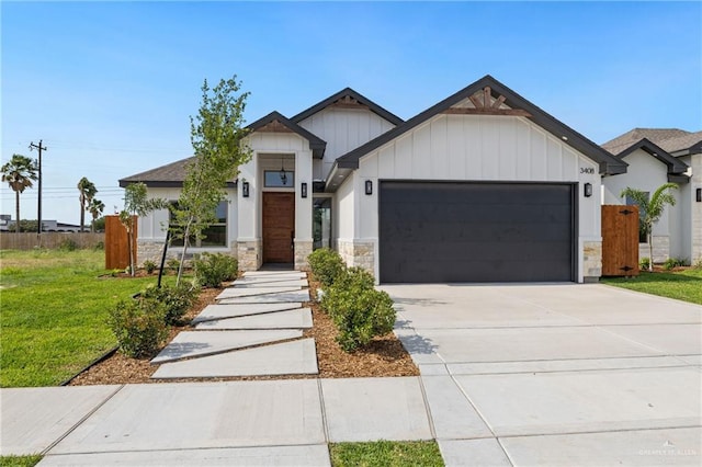 modern farmhouse featuring stone siding, a garage, board and batten siding, a front yard, and concrete driveway