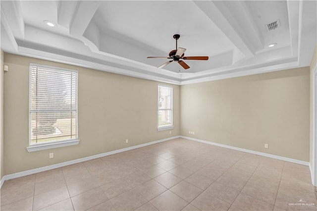 unfurnished room with a tray ceiling, baseboards, and visible vents