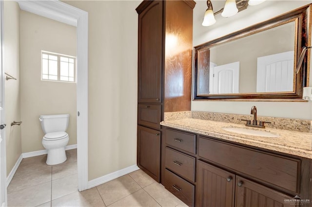 bathroom with tile patterned floors, toilet, vanity, and baseboards