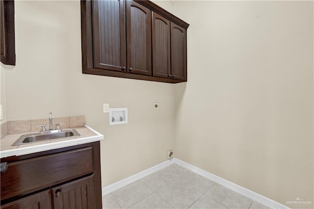 laundry room featuring baseboards, cabinet space, a sink, washer hookup, and electric dryer hookup