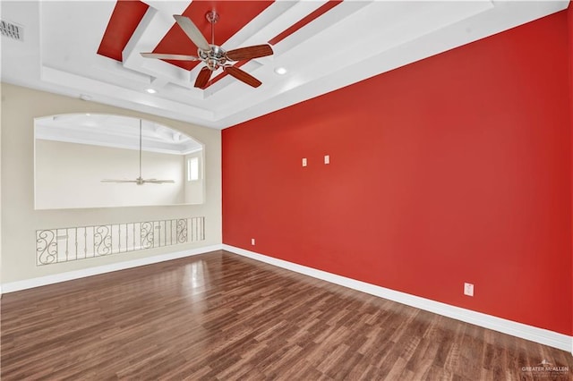 unfurnished room with visible vents, a ceiling fan, coffered ceiling, wood finished floors, and baseboards