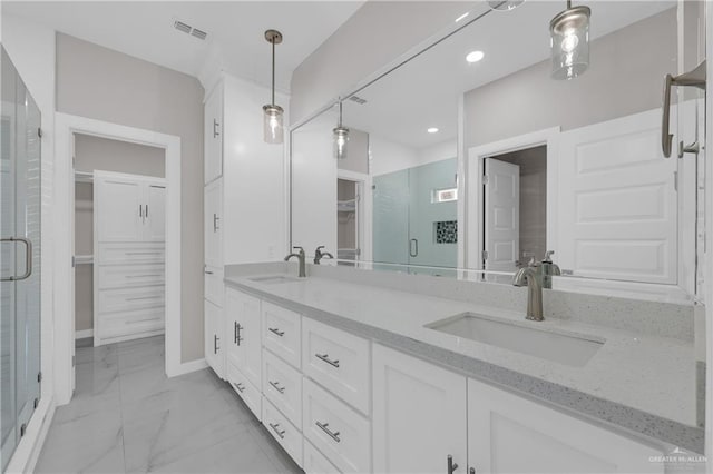 bathroom with marble finish floor, visible vents, a sink, and a spacious closet