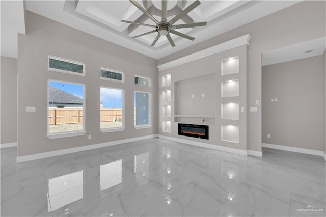 unfurnished living room with coffered ceiling, a ceiling fan, baseboards, marble finish floor, and a glass covered fireplace