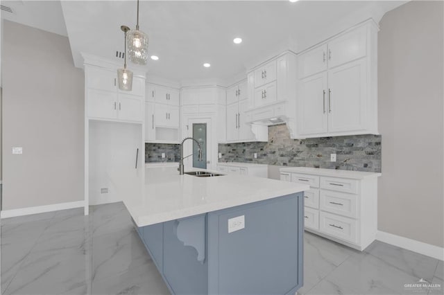 kitchen featuring marble finish floor, tasteful backsplash, a sink, and baseboards