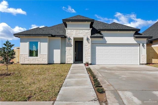 prairie-style house with stucco siding, an attached garage, a front yard, stone siding, and driveway