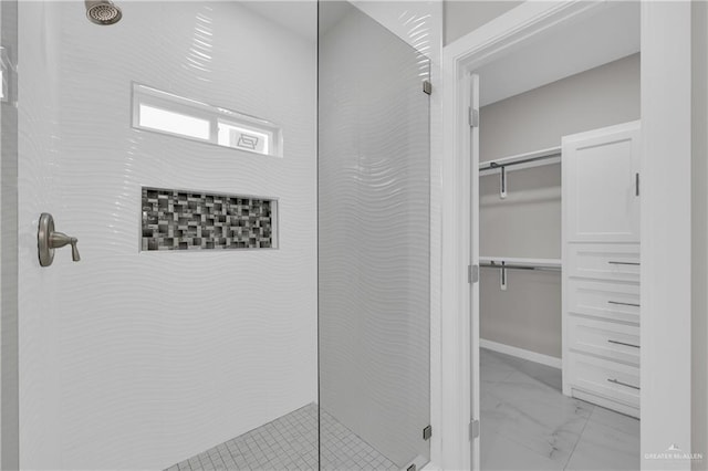 full bath with marble finish floor, a spacious closet, and walk in shower