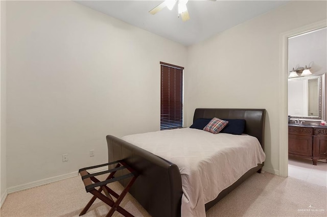 bedroom with ensuite bath, light colored carpet, and ceiling fan