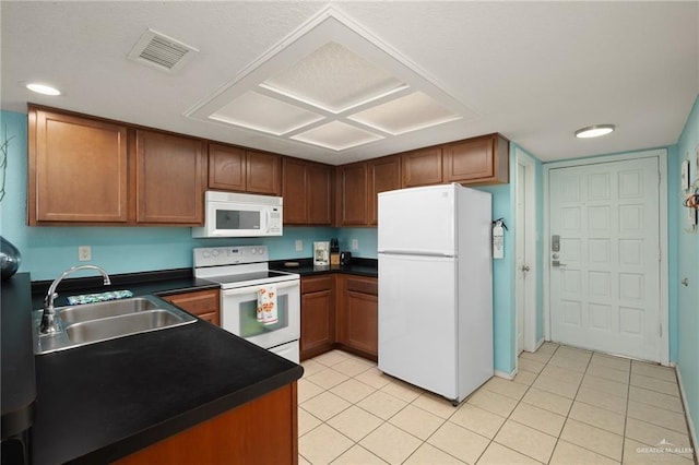108 E Coronado Dr Unit 207, South Padre Island, TX 78597 - kitchen with white appliances, dark countertops, light tile patterned floors, and brown cabinetry