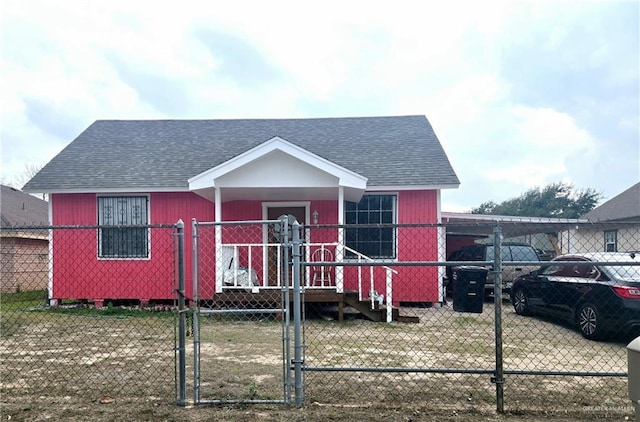 view of front of home featuring an attached carport, roof with shingles, fence, and a gate