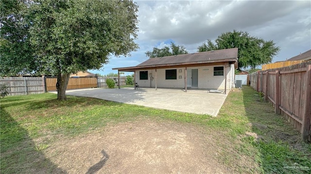 rear view of property with central AC, a yard, and a patio