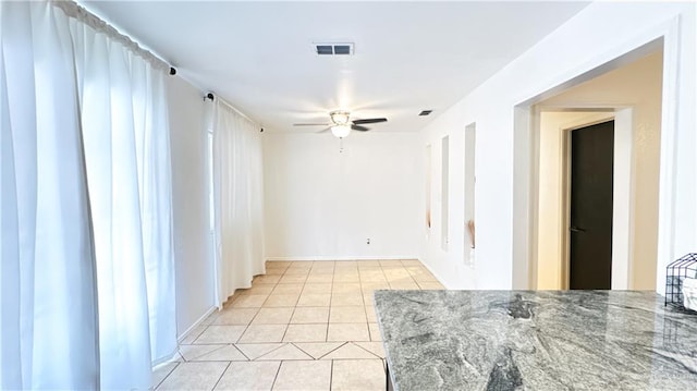 empty room featuring light tile patterned floors and ceiling fan