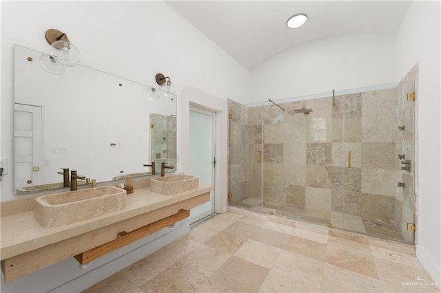 bathroom featuring a shower with door, vanity, and vaulted ceiling