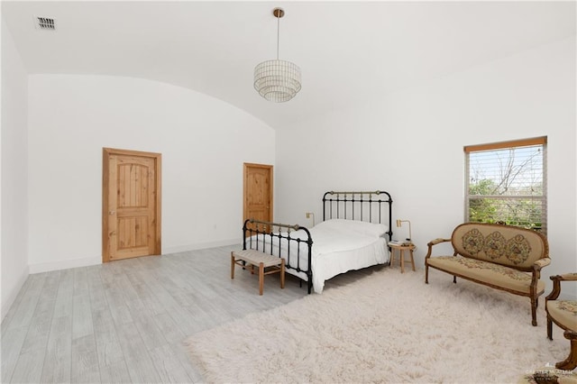 bedroom featuring light hardwood / wood-style floors and high vaulted ceiling