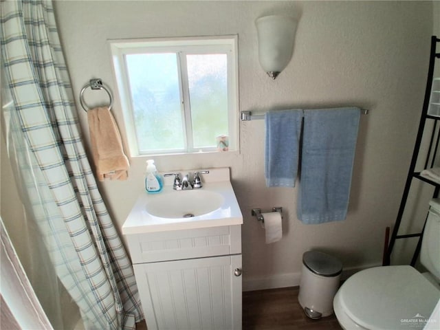 613 W Sprague St, Edinburg, TX 78539 - bathroom with vanity, toilet, curtained shower, baseboards, and wood finished floors